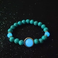 Luminous turquoise beaded bracelet with glow-in-the-dark blue stones on black background - Blue Turquoise Blue Light