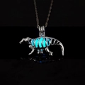 Macro shot of luminous hollow dinosaur skeleton pendant glowing blue in dark - Blue