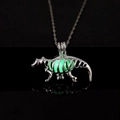Macro shot of silver dinosaur skeleton pendant with vibrant green glow-in-the-dark feature - Green