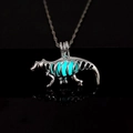 Detailed macro view of a luminous dinosaur skeleton pendant with a blue glow on black glass - Light Blue Glow