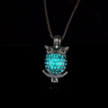 Detailed macro shot of the luminous owl pendant glowing in bright lake blue color - Light Blue Glow