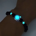 Bracciale di perline luminose con stella e luna e luce blu in ambiente oscuro - Oro Luce Blu