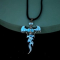 Macro shot of silver gothic skull pendant with blue wings and flame detailing on a cord - Leather Cord Blue Light