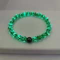 Detail shot of green luminous crystal beads with glowing flakes and black accent bead - Small / Green