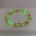 Detailed view of glowing orange glass beads emitting bright green light in the dark - Large / Pink