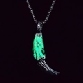 Vue macro du pendentif dent de loup luminescent avec revêtement vert fluorescent et métal noir - Vert