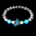 Detailed macro view of dolphin charm and luminous turquoise beads on a marble bracelet - White Turquoise With Blue Glow