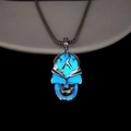 Detailed close-up of a hollow punk skull pendant with bright blue glow-in-the-dark feature - Blue