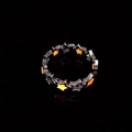 Detailed view of hollow star rings glowing in orange, yellow, and green in the dark - Silver Orange Red Glow