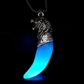 Close-up of a punk lion head and wolf tooth pendant glowing blue in the dark with a bead chain - Antique Silver Blue Glow