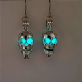 Makroaufnahme der im Dunkeln leuchtenden Totenkopf-Ohrringe mit cyanfarbener Fluoreszenz - Silber Blaugrünes Glühen