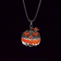 Detail view of a Halloween pumpkin face pendant on a metallic bead chain necklace - Orange