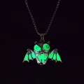 Macro view of Halloween demon wings necklace showing glowing green luminous effect in the dark - Luminous Green