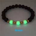 Macro shot of luminous green beads and volcanic stones on a lotus charm bracelet - Green