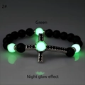Dettaglio del bracciale di perle nere opache con sfere luminose verdi e croce di strass - Argento Antico Luce Verde