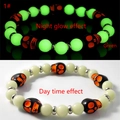 Glow in the dark Halloween skull bracelet showing daylight look and green luminous effect - Orange Skull Green Glow