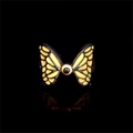 Macro shot of luminous butterfly ring with orange gradient wings and black bead on dark band - Orange Glow