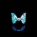 Luminous blue butterfly ring with glowing eye detail and black metal base on dark background - Teal Glow