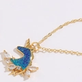 Dettaglio del ciondolo a unicorno dorato con glitter blu-verde e zirconi a marquise - Stile Unicorno (XL2052)