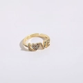 Gros plan d'une bague ajustable dorée à l'or 14K avec zircons colorés formant le mot LOVE - Zircone Colorée (LOVE Cœur)