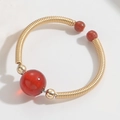 Vintage 14k gold plated ring featuring a large red agate bead on a flexible spring band - Red Agate Style