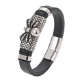Macro detail of men's leather bracelet featuring a silver spider charm and metal clasp - Spider