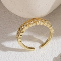 Bague ouverte coeur dorée ajustable avec zircons blancs sur une surface en pierre beige - Zirconia en Forme de S (JZ0237) - Or