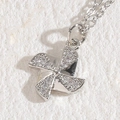 Silver windmill pendant necklace with sparkling cubic zirconia on a white stone background - Windmill White Gold
