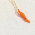 Goldene Halskette mit leuchtend orangem Hornanhänger, Sternrelief und Lochmustern - Orange