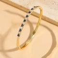 Elegant gold bangle with alternating blue and white pavé-set round cubic zirconia stones - Royal Blue Zircon Bangle