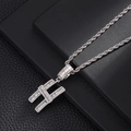 Macro shot of silver hip hop H letter pendant with baguette cut cubic zirconia stones - Letter H