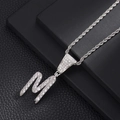 Detail van zilveren letter M hanger met zirkonia aan een gedraaide touw ketting - Letter M (Zilver) / 20 inch Touwketting