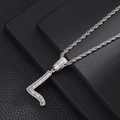 Macro detail of silver number 7 pendant with cubic zirconia on a black leather background - Number 7
