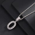 Close-up of hip hop silver letter O pendant with baguette-cut zircons on a rope chain - Letter O