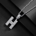 Close-up of hip hop silver H letter pendant with sparkling stones on rope chain - Letter H