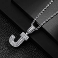 Macro shot of the ice-out letter J pendant featuring baguette cut zircons on a silver rope chain - Letter J