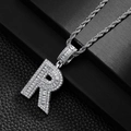 Close-up of hip hop silver letter R pendant with sparkling zircon inlays on a rope chain - Letter R