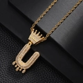 Gros plan sur un pendentif hip hop doré avec couronne, lettre U et zircons scintillants - Lettre U (Or)