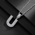 Macro shot of silver hip-hop U-letter pendant with baguette-cut sparkling zircons - Letter U