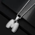 Detailed macro view of silver bubble letter M pendant with iced out pavé zircon stones - Letter M / Silver