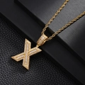 Detailed macro view of gold-plated letter X pendant with sparkling cubic zirconia inlay - Letter X Style