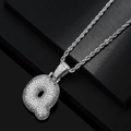 Macro shot of silver hip hop bubble letter Q pendant encrusted with clear cubic zirconia - Letter Q / Silver