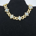 Detailed close-up of golden Cuban link necklace with blue marquise stones and infinity symbols - 8 inch / Gold Plated Blue Zirconia