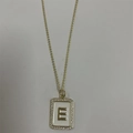 Golden letter E initial pendant necklace with sparkling cubic zirconia on white background - Letter E