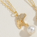 Détail macro du pendentif feuille de ginkgo avec zircons et perle blanche - Collier Feuille de Ginkgo Strass
