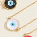 Makroaufnahme von Evil-Eye-Anhängern mit goldenen Titanketten und blauen Emaille-Einlagen - Weiß (MA2-3)
