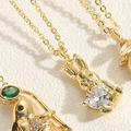 Macro shot of gold rabbit pendant necklace with sparkling heart-shaped zircon crystal - Heart Zirconia Rabbit Style (XL2627-MA2-1)