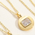 Macro view of gold necklaces with square cut cubic zirconia in round metal pendants - White Zirconia