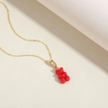 Close-up of red gummy bear resin pendant with cubic zirconia detail on gold chain - Bright Red (XL2599-8)