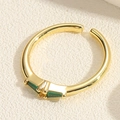 Detailed macro view of gold adjustable ring featuring two rectangular green zircons - Emerald Triangle Style